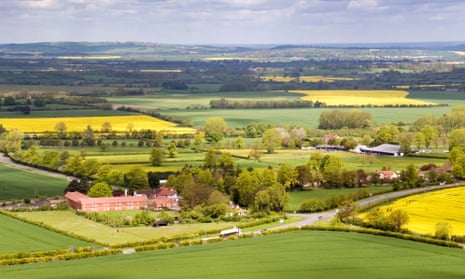 View over Aston Rowant in the Chilterns -view over Aston Rowant -green wheat + yellow rapeseed fields - woodland - farm buildings - sun + shadows