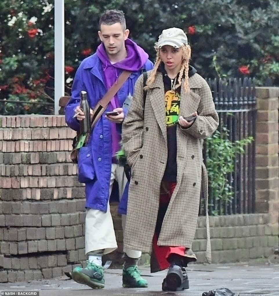 Bundled up: FKA twigs (real name: Tahliah Barnett) looked stylish in a large brown plaid coat that hung loose on her and kept her warm on the overcast day