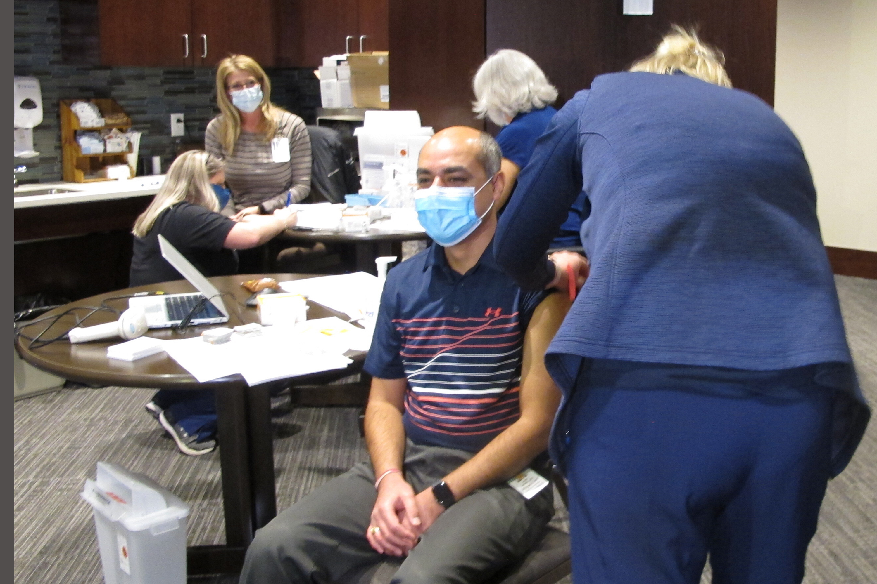 Dr. Avish Nagpal, an infectious disease specialist who has been treating COVID-19 patients at Sanford Health in Fargo, N.D., receives the first shot of the coronavirus vaccine given in North Dakota on Monday, Dec. 14, 2020. The hospital was the first to receive the vaccine in the state and started giving shots to frontline workers in COVID units, intensive care units and emergency departments. North Dakota has been among the worst states in the nation for virus outbreaks.