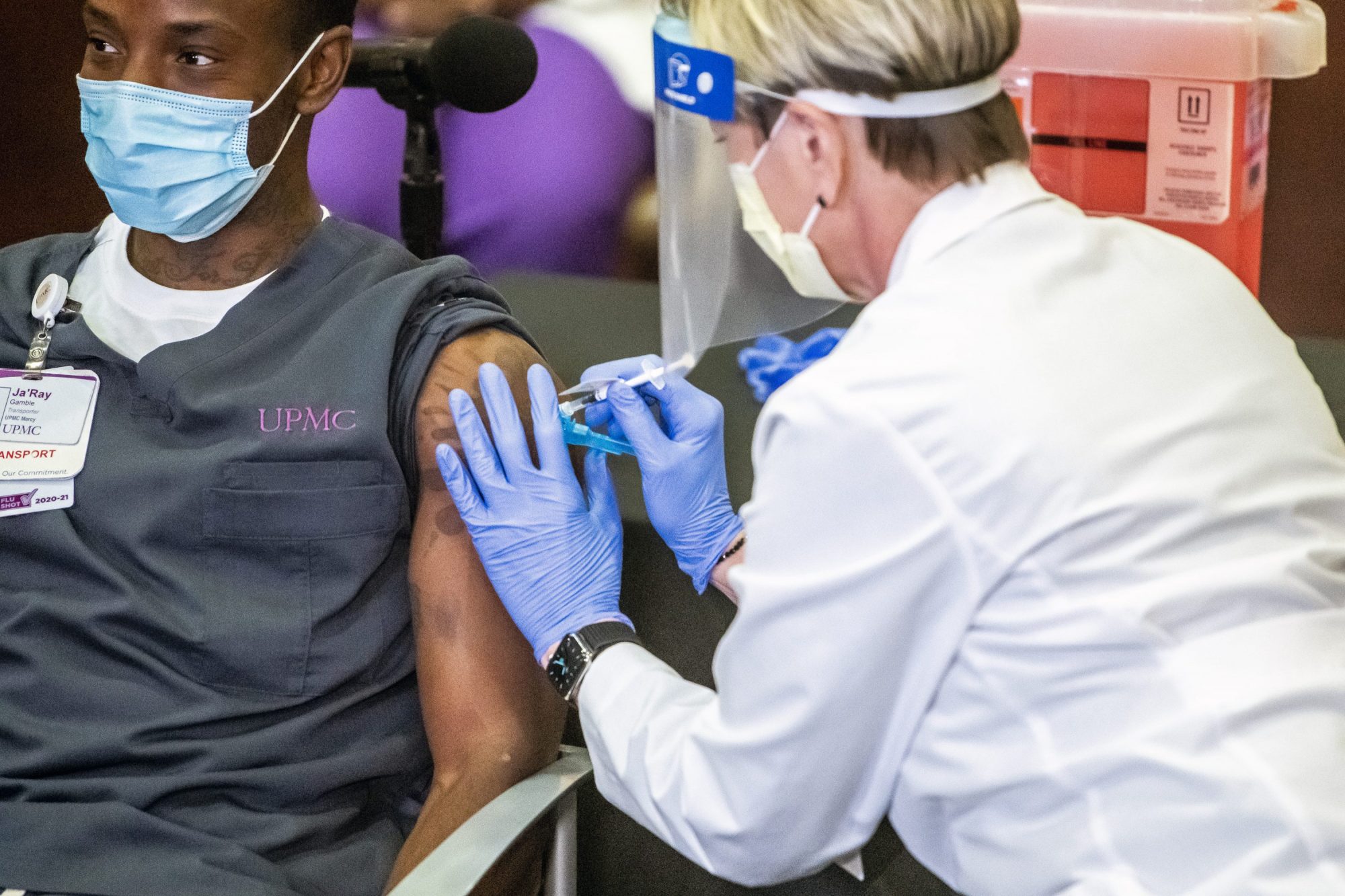 Ja'Ray Gamble, a transporter at UPMC Children's Hospital of Pittsburgh, receives Pfizer's COVID-19 vaccine from Tami Minnier, chief quality officer, at UPMC Children's Hospital of Pittsburgh, Pa., Monday, Dec. 14, 2020, in Lawrenceville. Five healthcare workers received the vaccine shortly after it arrived at the facility.