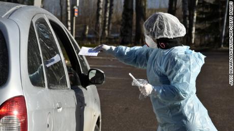 Medical workers take samples from patients at a coronavirus drive-in test center in Espoo, Finland, on April 1, 2020. (Jussi Nukari/Lehtikuva/AFP)