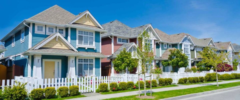 Great and comfortable neighborhood. A row of townhouses behind wooden fence at the empty street.