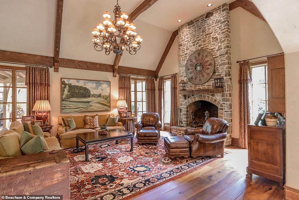 How the other half live: In that room what appears to be an old round shield is hung over the mantelpiece, just above two comfortable-looking leather armchairs with matching ottomans