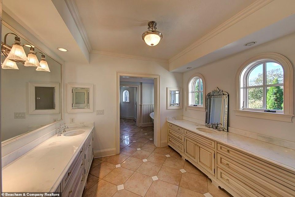 Setup: One vanity room has a mirror spanning the entire length of one wall, with small vaulted windows along the opposite wall giving a glimpse of the trees outside