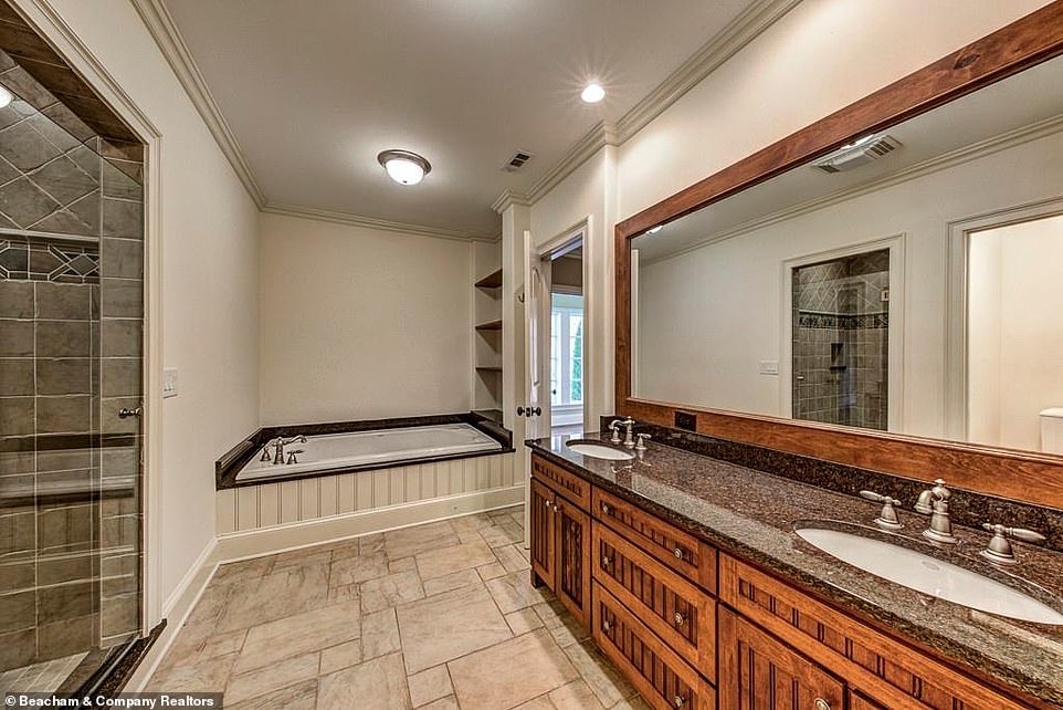 Luxe to the hilt: A smaller bathroom is still handsomely appointed with log-cabin-chic wood paneling around the mirror to match the cabinets underneath the sinks