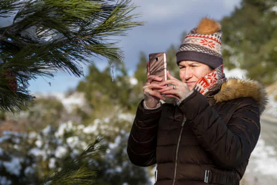 Woman taking a photo in winter (posed by model)