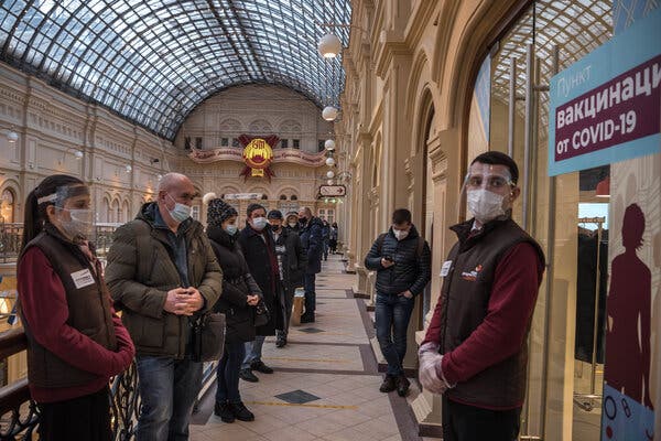 People wait in line to receive the Sputnik V coronavirus vaccine at the State Department Store GUM in Moscow.