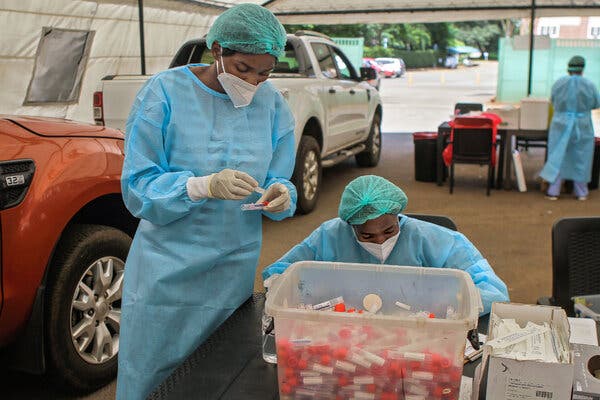 Health care workers gathering samples at a coronavirus testing site in Harare, Zimbabwe on Friday. The Covax global initiative is purchasing vaccine doses from Pfizer to distribute among its member nations.