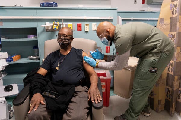 A healthcare worker administers a Covid-19 vaccine in Harlem on Friday. The C.D.C. has updated its guidelines on vaccine doses from multiple manufacturers.