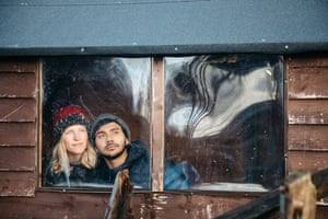 Emma Friend and Caleb Socrates watch from their garden shed