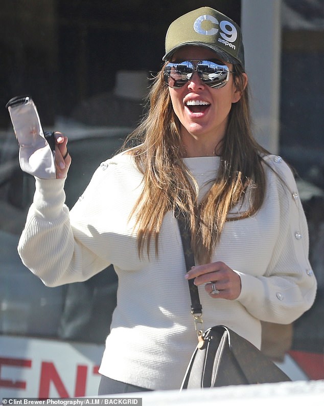 Casual outing: Dodd kept it casual in a white sweater with a green C9 Aspen trucker hat and some frameless mirrored aviator sunglasses