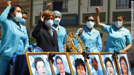 Health workers in the highland city of Puno in the Andes, protest with pictures of their co-workers who died during the pandemic in August.