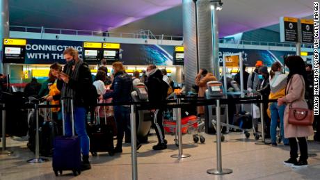 Passengers queue at a check-in desk at Heathrow Airport in London on December 21.