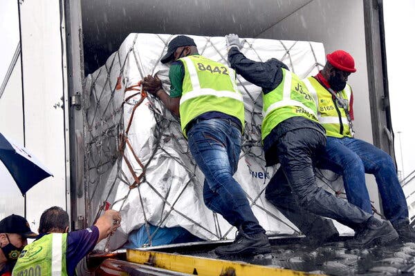 Workers loading South Africa’s first coronavirus vaccine doses at OR Tambo airport in Johannesburg on Monday.