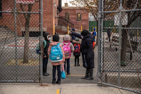 Students waiting to be admitted at a public school in Brooklyn in December. In New York City, about 12,000 more white children have returned to classrooms than Black students.