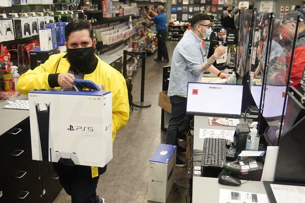 An employee at a GameStop store in Manhattan in November with a Sony PS5 console. The new machines led to big profits in software and network fees for Sony.