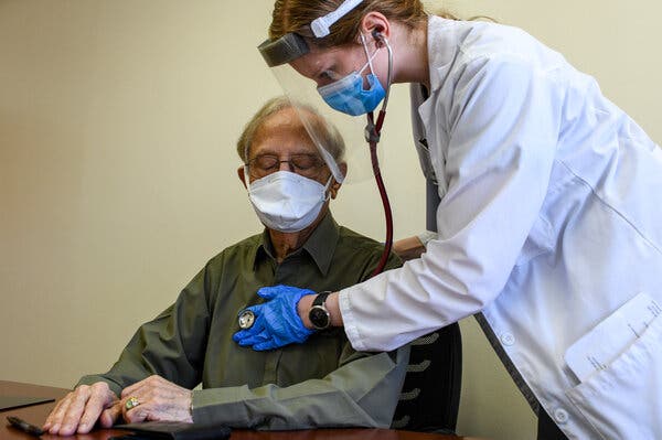 A volunteer is examined by his doctor during a medical screening ahead of receiving the Novavax vaccine at Howard University Medical Center in Washington on Jan. 15.