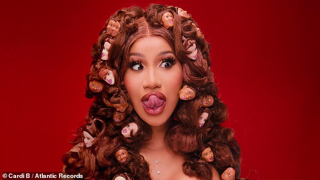 Doll face: Cardi also had some support from some backup singers, in the form of Barbie doll heads strewn through her hair