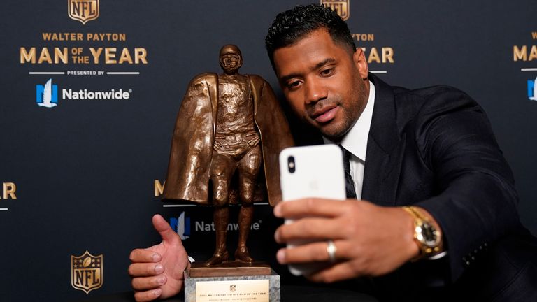 Russell Wilson poses with the Walter Payton trophy (AP Photo/Charlie Riedel)