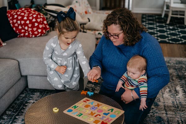 Maggie Owens and her children, Louise and August, playing in their Chicago home. The city’s teachers approved a deal early Wednesday that would send students, including Louise, back to classrooms.