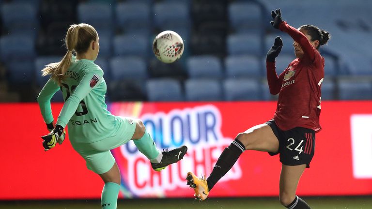 Ellie Roebuck clears the ball ahead of the onrushing Christen Press