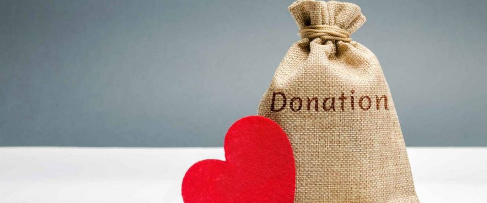 A money bag with the word Donation and a red heart. Accumulation of money for a medical donation. Health care. Saving. Social medical help from volunteers. Charitable foundation