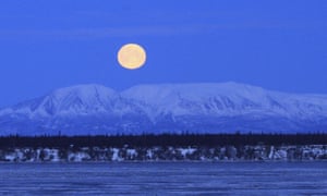 The moon sets over Mount Susitna, across Cook inlet, in Anchorage, Alaska.