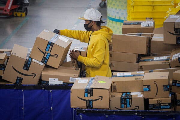 An employee scans packages at Amazon’s distribution center in Staten Island, N.Y., November 2020. Conditions at the site is the focus of a lawsuit.