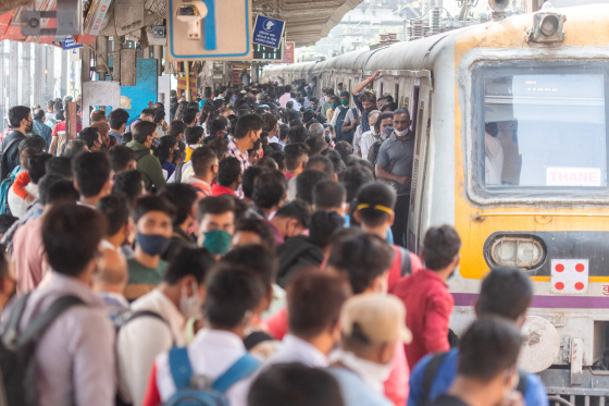 A rush of travellers wait to board a suburban local train at Dadar station, Mumbai, on the first day when local train services started for general public on Feb 1.