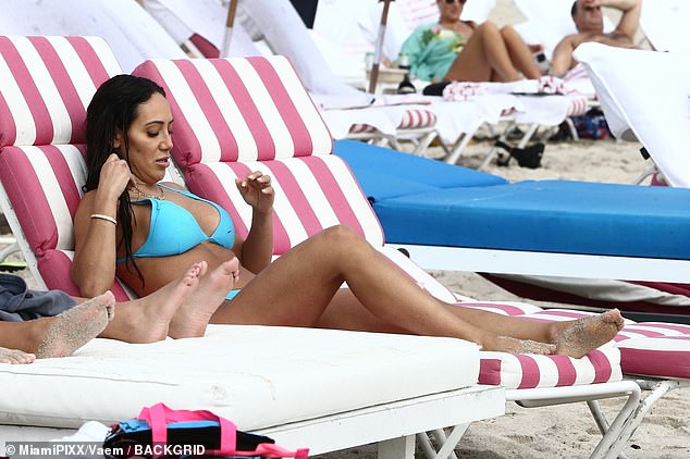 Rest and relaxation mode: Melissa enjoyed a break from the water on a pink and white striped lounge chair