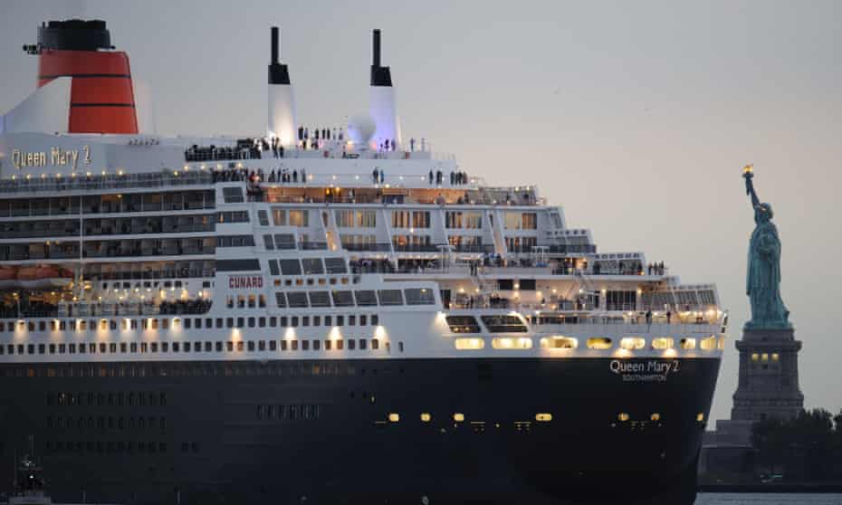 The Queen Mary 2 sails past the Statue of Liberty in New York.