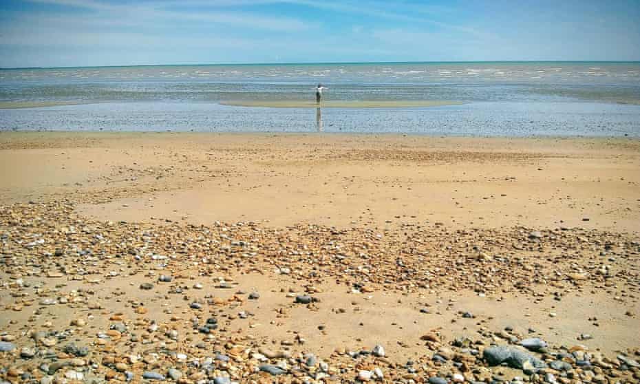 Person on a sandbank in Sandwich bay