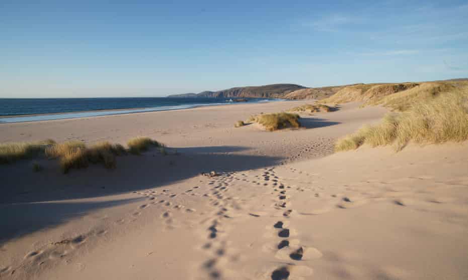 Footprints leading across pristine sandy beach of Sandwood bay,