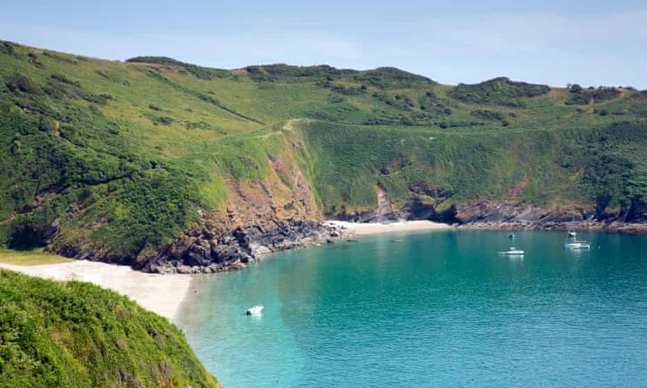 Beaches at Lantic Bay with blue sea and green cliffs behind