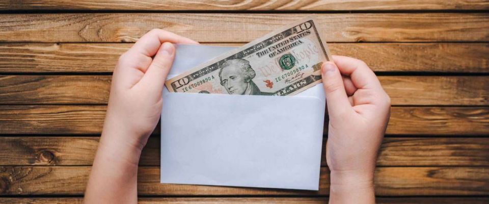 Dollar in an envelope in children&#39;s hands