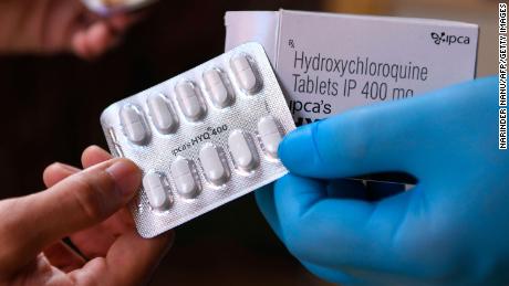 A vendor displaying hydroxychloroquine tablets at a pharmacy.