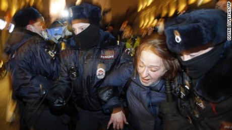 Police officers detain a Navalny supporter during a protest in St. Petersburg on Tuesday.