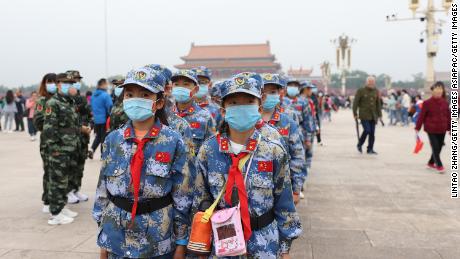 Chinese Young Pioneers wearing face masks take part in a flag-raising ceremony at Tiananmen Square on October 1, 2020 in Beijing, China.