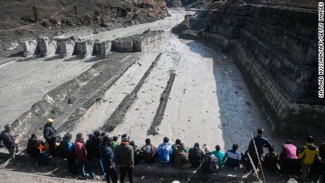 People look at the remains of a dam along a river in Tapovan of Chamoli district on February 9, 2021.