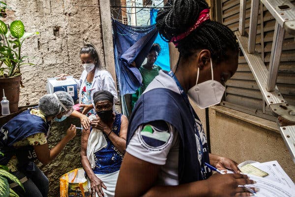 Justina Roberta Santos, 84, received a coronavirus vaccine during a campaign to inoculate older people with mobility issues, in Rocinha, Brazil, last month.