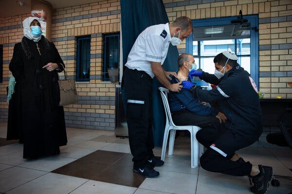 An Israeli medical worker administering the Pfizer-BioNTech vaccine to Palestinians at a checkpoint between the West Bank city of Ramallah and Jerusalem on Feb. 23.