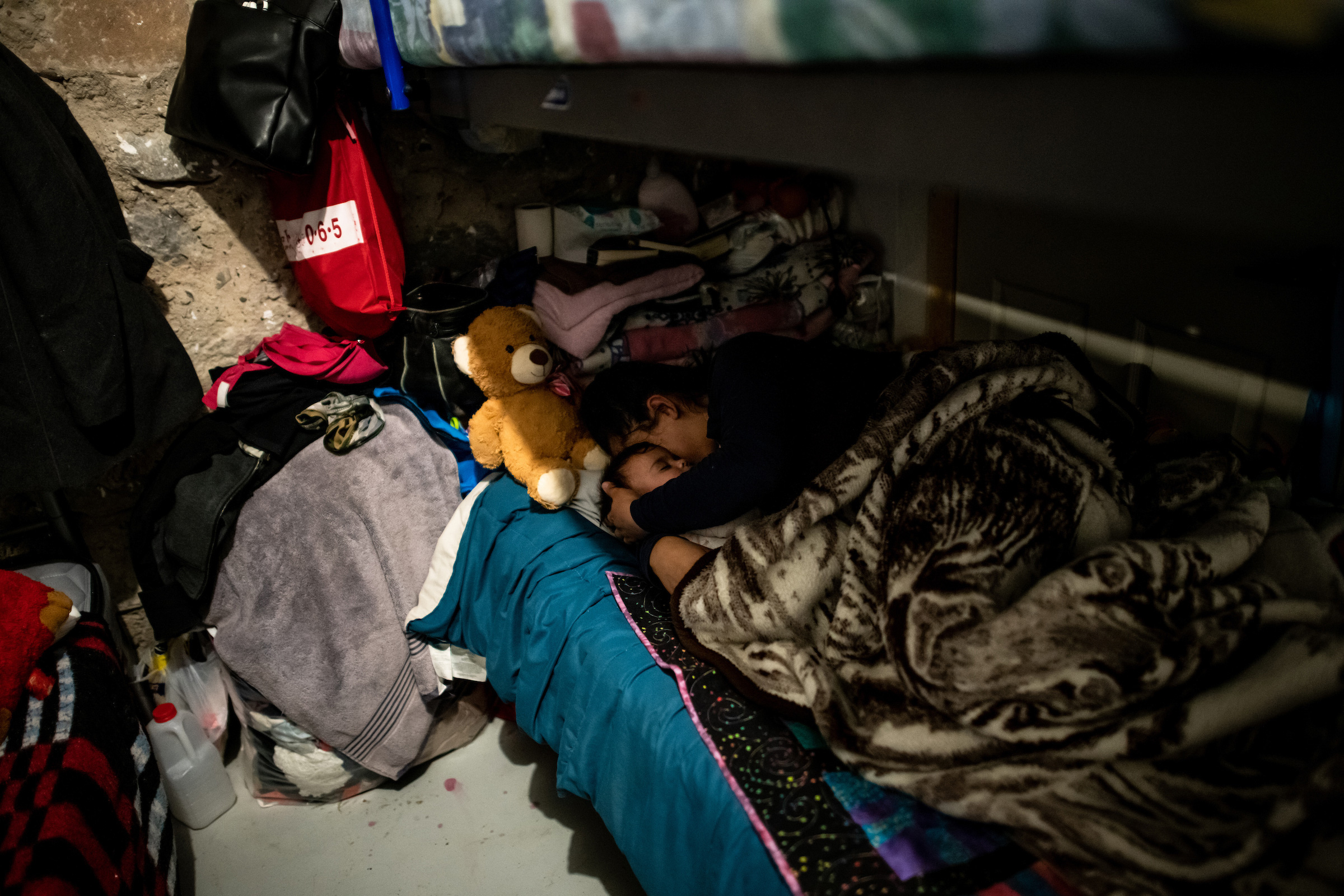 Xiomara lays down with her baby in one of the dormitories.