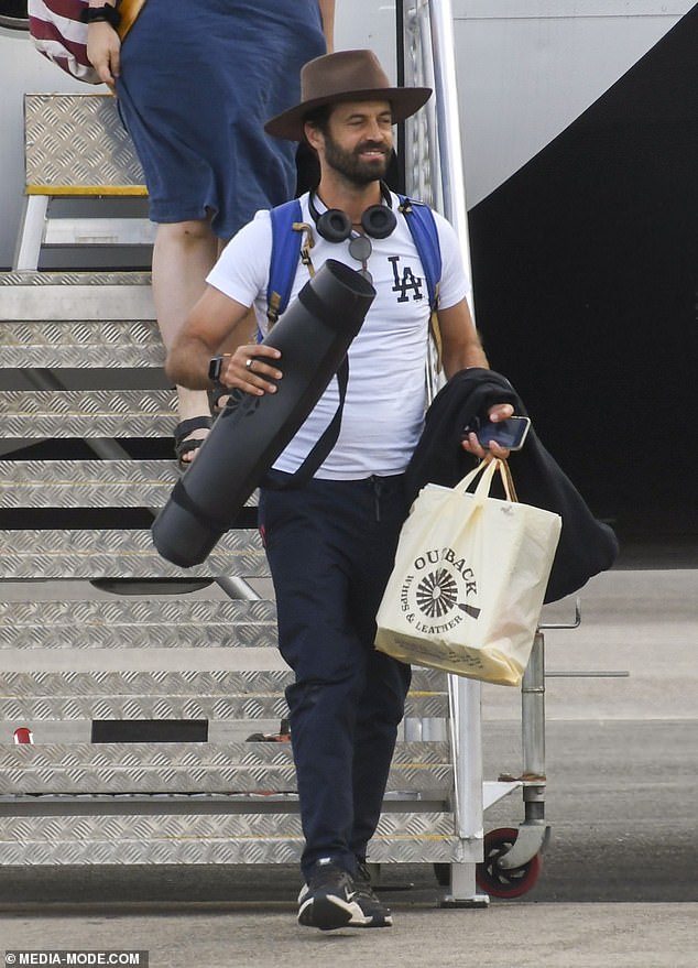 A look: Meanwhile, director Benjamin opted for a comfortable pair of navy track pants and a white Los Angeles branded t-shirt