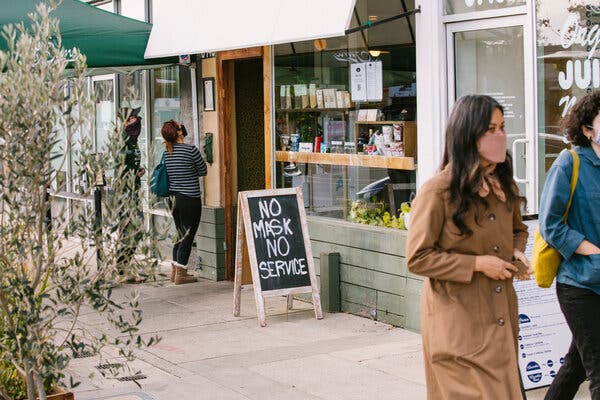 People in masks outside a restaurant in the Atwater Village neighborhood in Los Angeles in January.