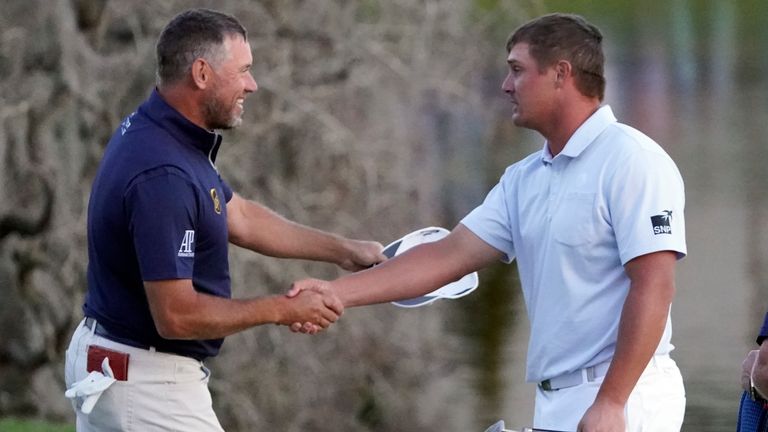 Lee Westwood shakes hands with DeChambeau