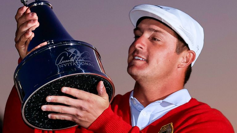  DeChambeau admires the trophy