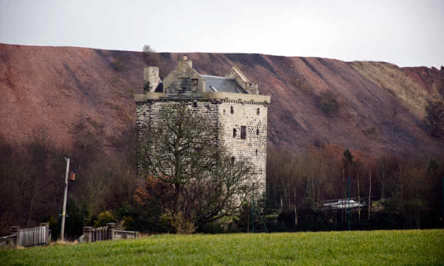 Niddry Castle, near Winchburgh, with a large oil shale bing behind it, in Scotland, UK.