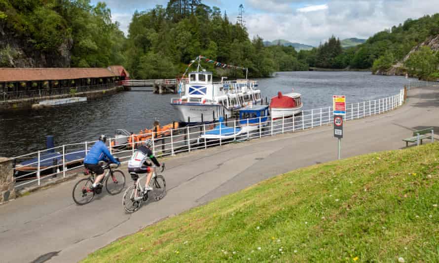 Trossachs Pier, Loch Katrine, Scotland, UK - cyclists passing the Lady of the Lake cruise boat