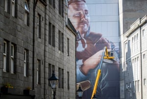 Street artist Sam Bates, AKA Smug, creates a mural during the Nuart festival.