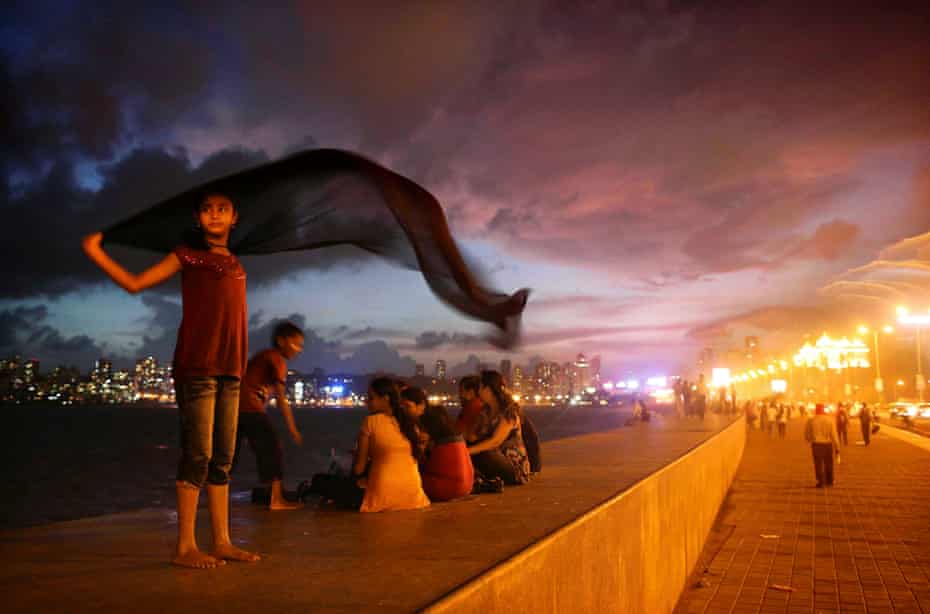 A girl dries a sari following rains on Marine Drive along the Arabian Sea in Mumbai, India,